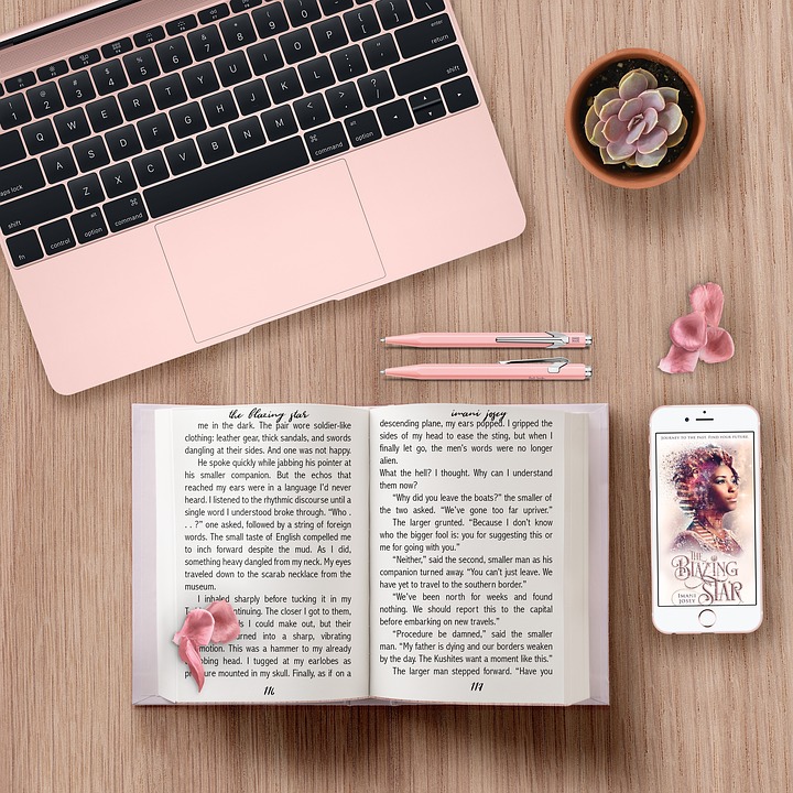 Desktop with laptop, book, pens, and smartphone Image
