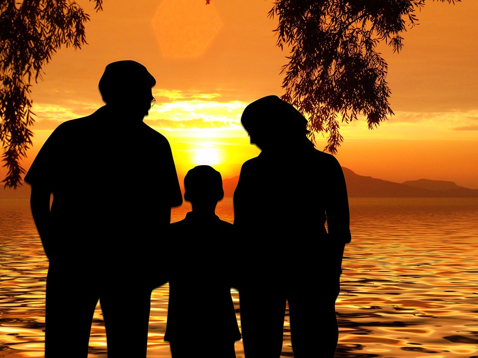 Family looking at sunset across a lake image