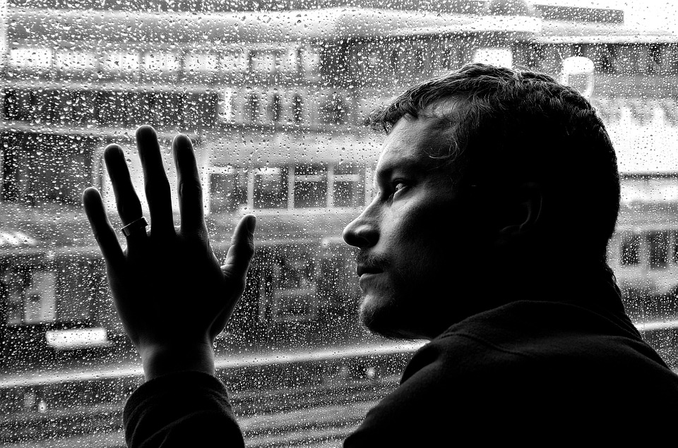 lonely man looking out window image