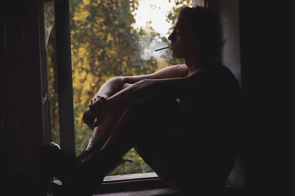 Man Sitting in Windowsill Smoking Image