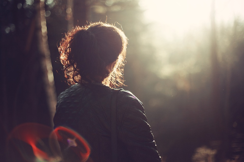 Woman looking at sunset in the woods image